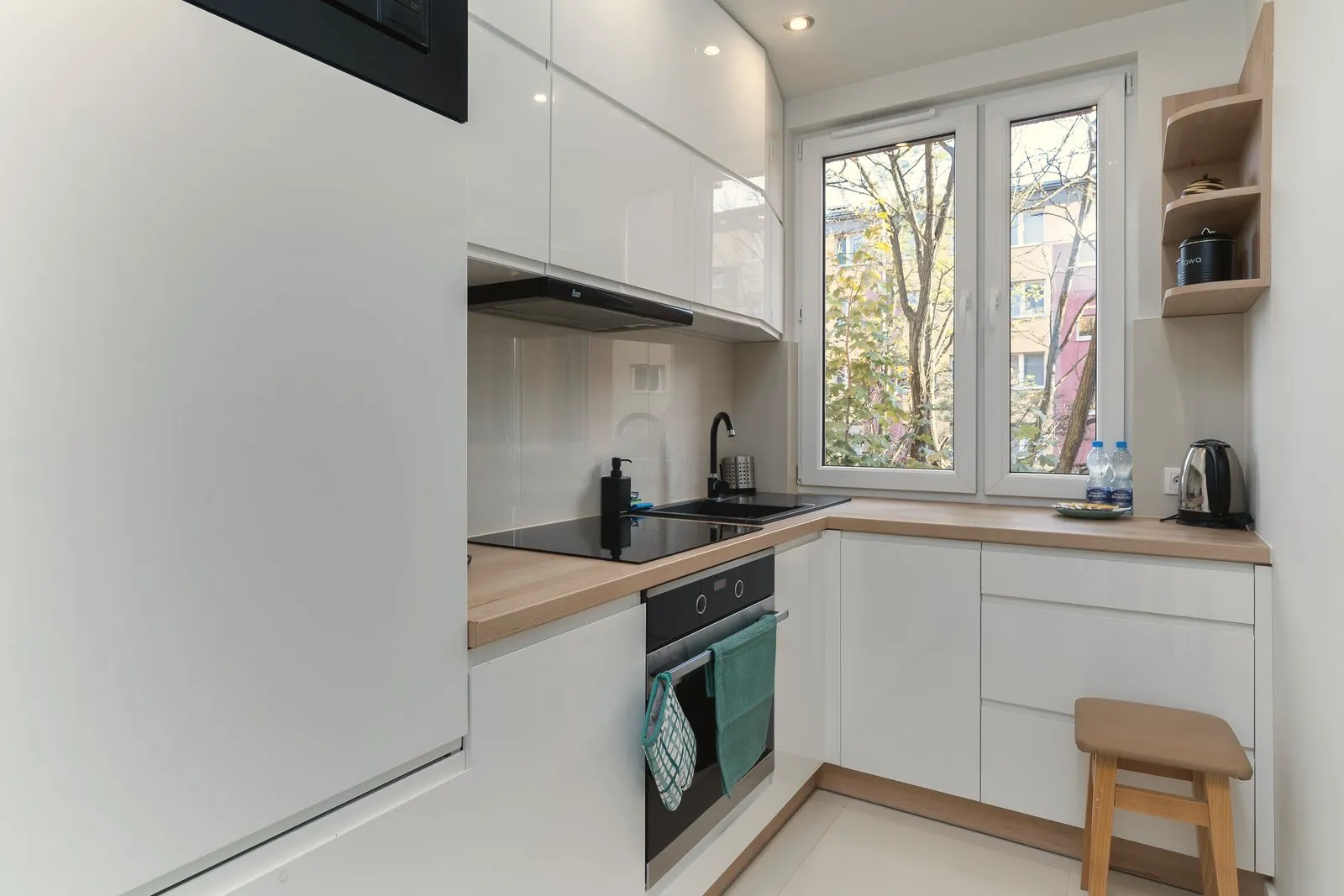 White L-shaped modular kitchen with oak worktop
