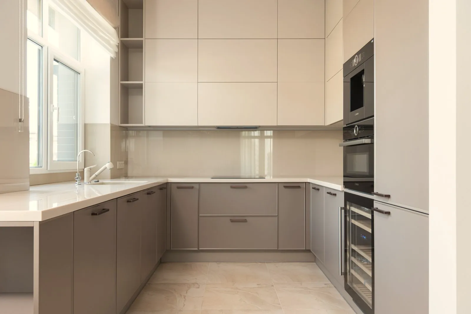 Greige U-shaped modular kitchen under a window