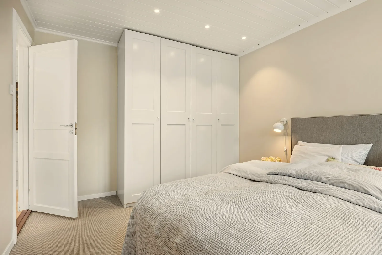 White hinged wardrobe in a bedroom